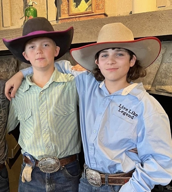 Two boys in button downs and jeans with cowboy hats and belt buckles. Pictured are Ryder Dillard and Jaxson McNutt  